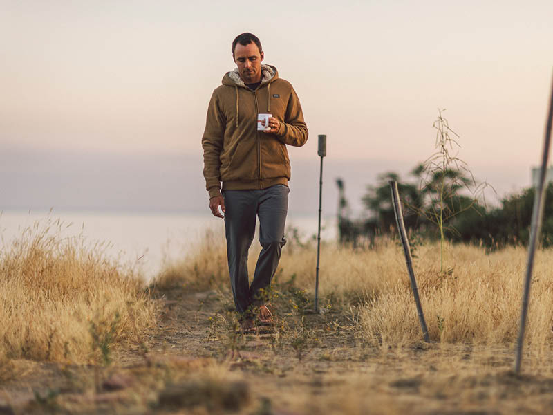 Sippin'' some coffee, wearing a hoodie, on a gloomy morning at the beach.