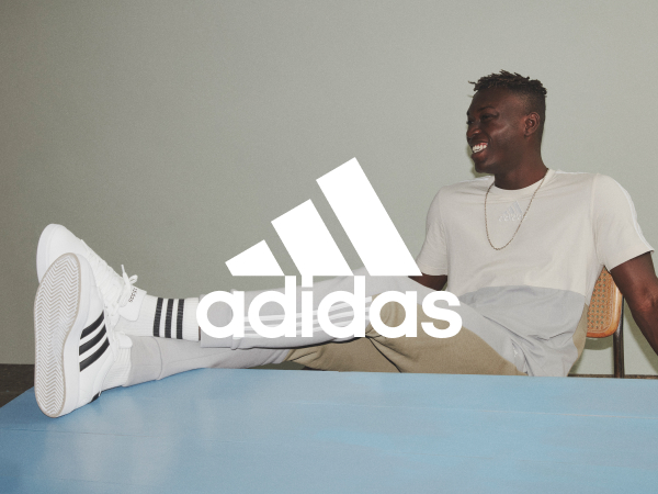 Man sitting on a chair in adidas gear. White adidas logo on top of the image.